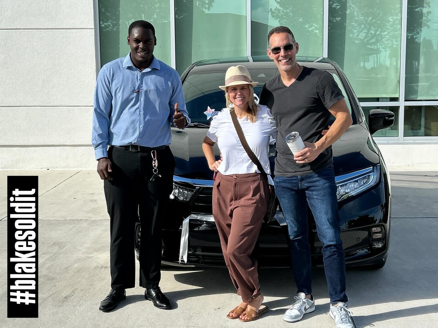 Client picking up her new car with the signature Blakesoldit red bow on the hood, parked outside a South Florida dealership at night